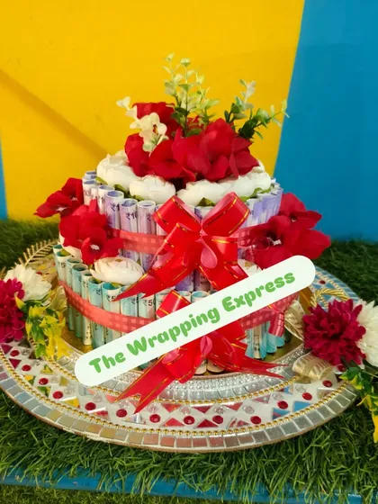 This wedding cash platter is set on a decorative thali and adorned with red flowers. It’s a traditional yet creative way to give your blessings.