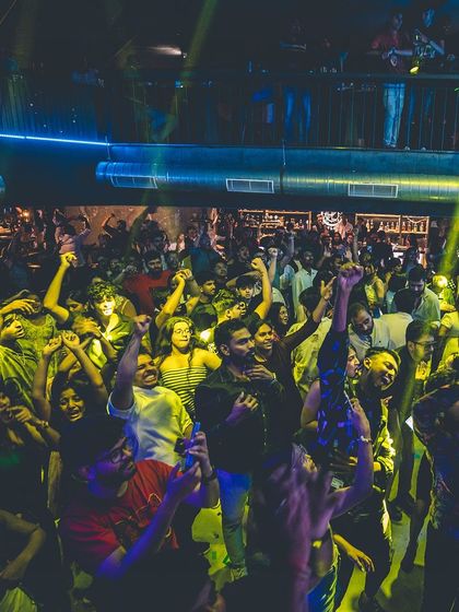 The crowd at Flo, united in dance. The yellow and blue lighting creates a dynamic and vibrant atmosphere.