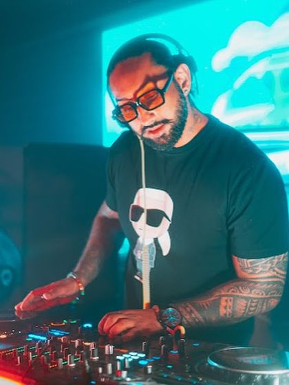 Mixing tracks under the cool blue and orange lights in Kolkata. The right lighting is crucial for setting the mood, and I work with venues to create the perfect vibe.