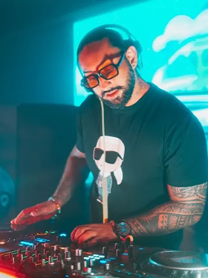 Mixing tracks under the cool blue and orange lights in Kolkata. The right lighting is crucial for setting the mood, and I work with venues to create the perfect vibe.