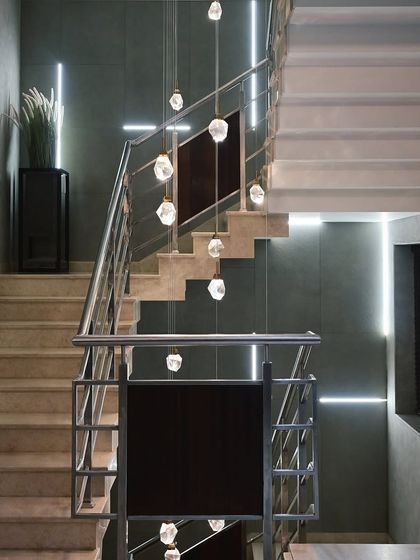 In this staircase, we used a combination of recessed linear lights and decorative pendants. The entire setup is automated to provide both functional path lighting and a beautiful design feature.