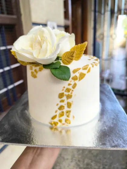 Showcasing a more classic and elegant style, this mini cake features a pristine white finish, a sophisticated gold mosaic pattern, and is topped with delicate, handcrafted sugar paste roses.