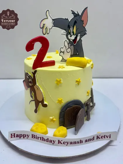 A fun Tom and Jerry theme cake for a 2nd birthday. This chocolate truffle cake shows Tom and Jerry in a classic chase scene, complete with little fondant cheese details.