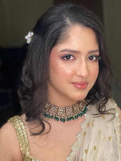 A closer look at this golden glow makeup. The skin looks radiant and fresh, and the soft eye makeup perfectly complements her traditional choker necklace.