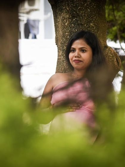 Using natural elements to frame the subject can create a beautiful, artistic effect. Here, the leaves provide a soft focus, drawing attention to the serene mom-to-be.