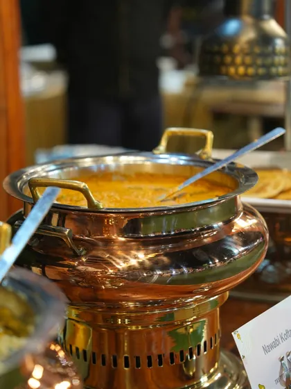 A rich and creamy Nawabi Kofta curry simmering in an elegant copper serving dish. This is a glimpse into our luxurious North Indian main course offerings.