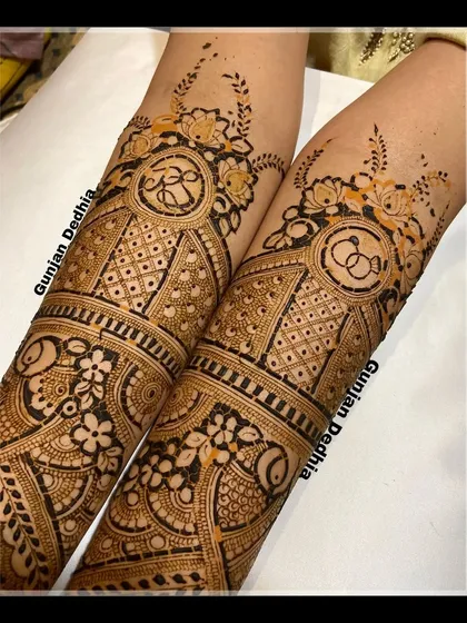 A close up of the arm portion of an engagement mehendi, showing the detailed ring symbols and floral patterns.