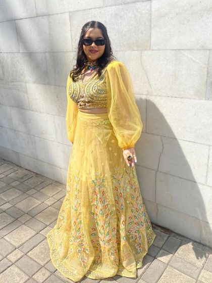 A beautiful yellow lehenga with delicate multicolour embroidery and dramatic balloon sleeves. This is a modern and stylish choice for a haldi or sangeet, offering a unique silhouette that stands out.