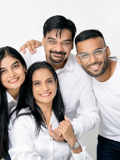 A warm and happy family portrait with grown children. The close, hugging pose shows the lasting bond and affection within the family.