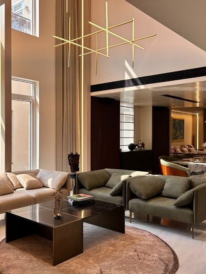 The living area in the Palm Springs Villa is designed for comfort and conversation. We used a combination of plush sofas in neutral and olive green tones, set against a backdrop of warm, ambient lighting and double-height windows to create a sophisticated yet welcoming family space.