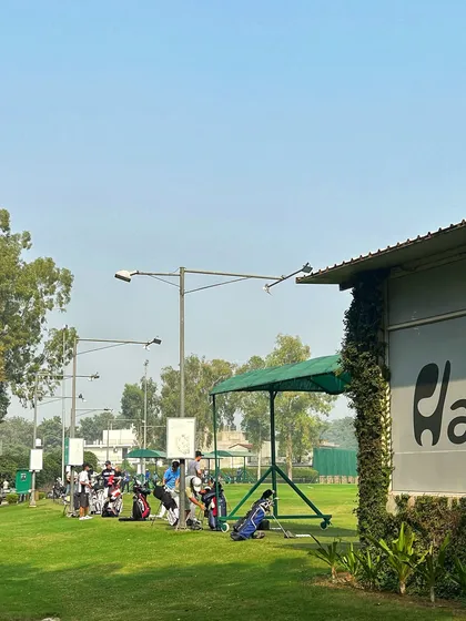 A view of the range from the side, showing our branding and a full line of active golfers.