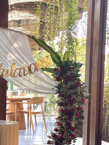 A different angle of the floral arch, highlighting the "Congratulations" sign and the lush greenery.