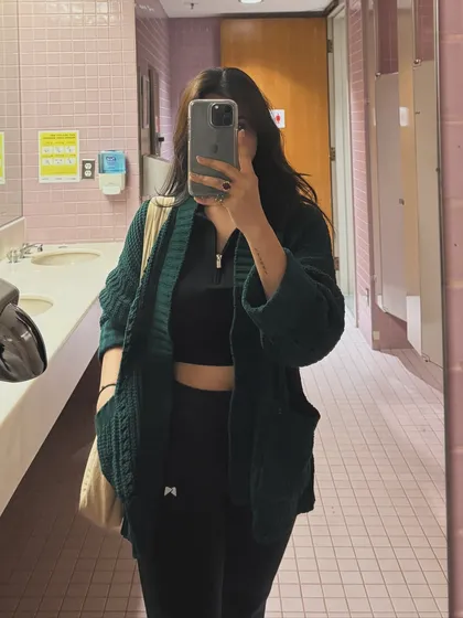Another mirror selfie of the green cardigan outfit, providing a different angle and lighting.