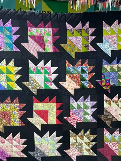 A "basket" quilt, where each block is a colorful patchwork basket set against a solid black background.