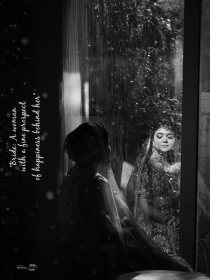 A black and white portrait of the bride looking through a window. The text overlay adds a poetic touch to this contemplative and beautiful shot.