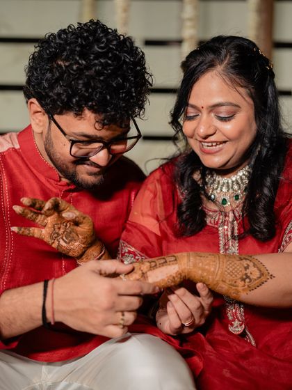 A close-up of the couple admiring the bride's mehendi, a classic pre-wedding ritual.