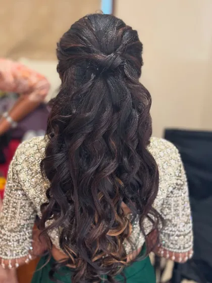 Another angle of Haritha's reception hairstyle, showing the beautiful texture and volume of the curls. This style is perfect for a modern, glamorous look.