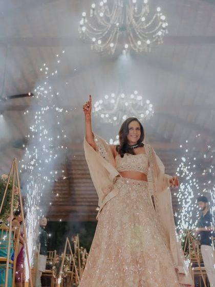 Making an entrance that feels like a movie scene. The bride arrives at her Sangeet, surrounded by cold pyrotechnics, ready to celebrate in style.