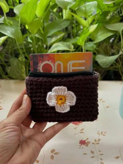 A simple and sweet crochet wallet, perfect for your cards. The white flower applique on the dark brown base creates a lovely contrast.