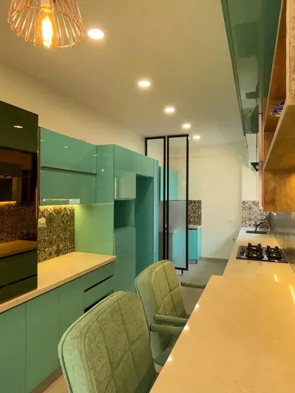 Our execution includes the seamless integration of built-in appliances and custom storage solutions. Here you can see the handleless drawers and cabinets, all finished in a high-gloss laminate for a sleek, modern look.