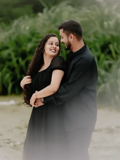 An intimate portrait of a couple sharing a loving look. The soft focus and natural green background create a romantic and dreamy atmosphere, perfect for a pre-wedding or couple's photoshoot.