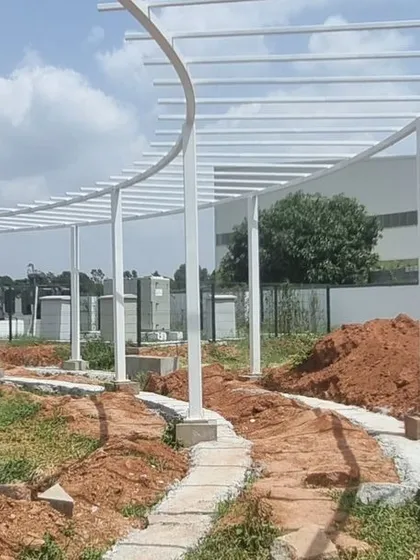A duplicate image of the pergola framework, showing the foundation work and the raw, graded earth before planting.