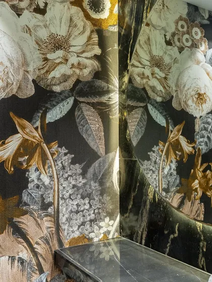 Wallcoverings in a powder room go beyond aesthetics, offering a unique blend of texture and design. This dramatic floral mural from Londonart Wallpaper creates an immersive and luxurious experience in a small space.