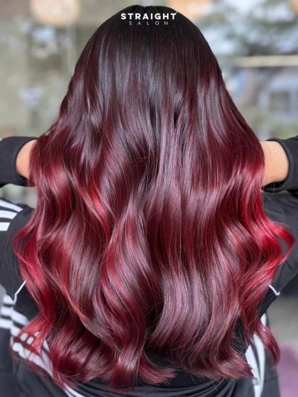 Bringing the cozy vibes with this rich red balayage. The color melts from a dark root into bright, fiery ends.
