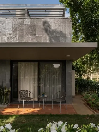 A private sit-out at the DUBEY Home, featuring a facade clad in local Sadarhalli slate. This detail shows our commitment to using durable, regional materials and creating intimate outdoor spaces for relaxation.