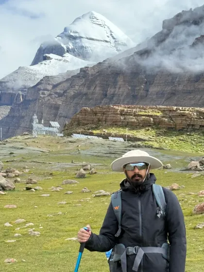 Standing before the south face of Kailash, equipped for the journey ahead. The path is rugged, but the spirit is willing, drawn by the immense presence of the mountain.