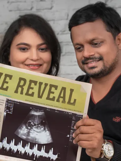 A close-up on the "The Reveal" newspaper prop, showing the baby's first ultrasound scan. A creative and personal way to announce your pregnancy.