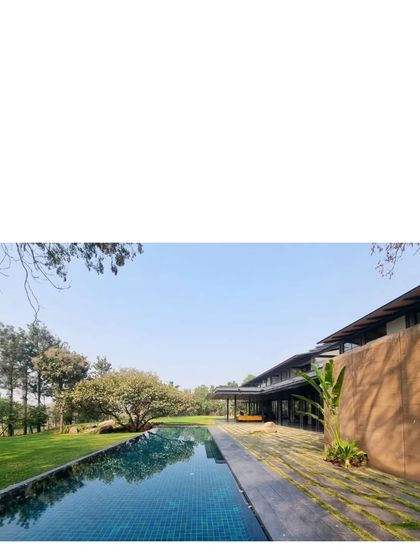 The long, low profile of the Lakeshore house reflected in the infinity pool. The design emphasizes horizontal lines that echo the horizon of the lake.