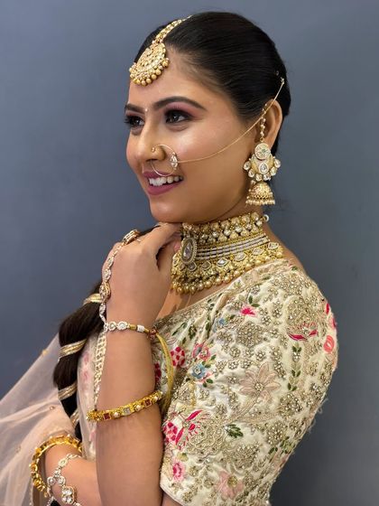 A side profile of this stunning bride, showcasing her elegant nath and jhumkas. The makeup is kept classic and timeless to let the jewelry and outfit shine.
