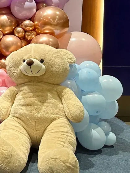 A giant, cuddly teddy bear is the perfect centerpiece for a baby shower. We often include large props like this to add a cute and memorable element to our teddy bear themed decorations.