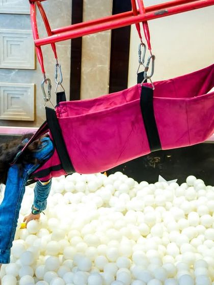 The human catcher game is a unique attraction where a child is safely harnessed and lowered into a pit of prizes or balls to grab as much as they can.