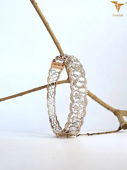 This elegant bracelet features pear-cut diamonds that gleam like morning dew, set in a delicate gold filigree that mirrors nature’s own poetry.