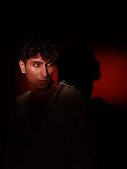 A creative shot showing the model's shadow cast on the wall behind him.