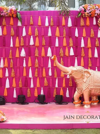 A playful and picturesque photo booth for a Haldi. The backdrop features a wall of colorful tassels and a life-sized elephant statue, offering a fun and memorable spot for guests.