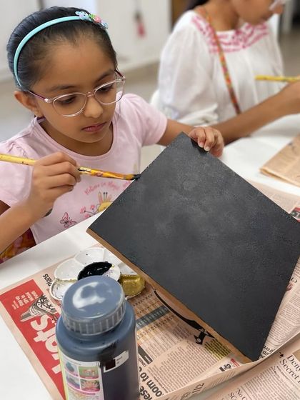 Painting the board black provides a dramatic background for the bright orange pumpkin string art.
