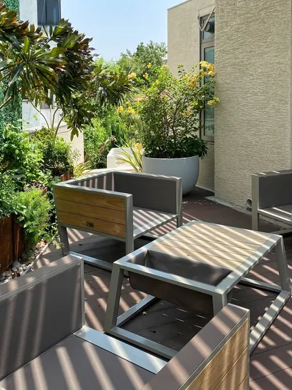 In this urban 'House of Terraces,' I used a minimal trellis to cast linear shadows, creating a dynamic play of light and shade. The custom outdoor furniture and lush planters transform this city space into a private, functional, and beautiful outdoor living room.