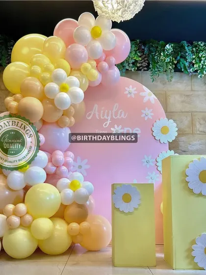 A lovely daisy-themed setup with a pink backdrop. The pastel yellow and pink balloons, along with daisy cutouts, create a soft and cheerful atmosphere.
