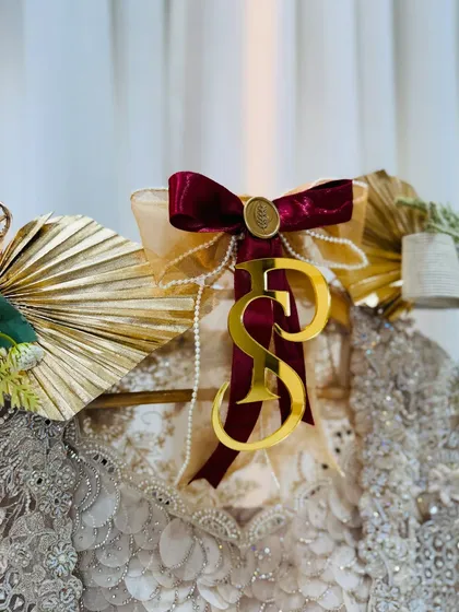 A velvet ribbon in deep burgundy, a custom wax seal, and a personalized initial tag add a layer of classic luxury to this bridal outfit.