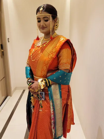 A side view highlighting the intricate details of the drape and the bride's traditional accessories.