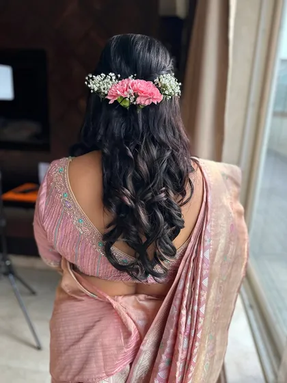 Soft waves with a half-up twist, adorned with a beautiful fresh flower arrangement. This look is both romantic and effortlessly chic.