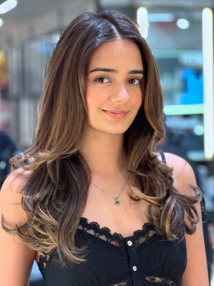 A beautiful transformation using Redken color. The client's smile says it all. The balayage adds soft, flattering highlights that brighten her entire look.