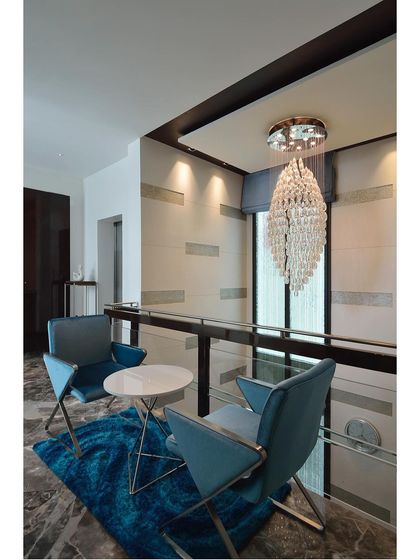 A showcase of cozy seating areas created in transitional spaces like landings and hallways, featuring elegant chandeliers and comfortable chairs.