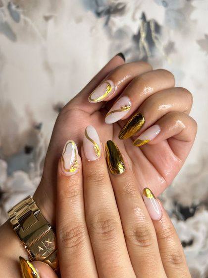 A high-fashion set with a milky white base, gold chrome accents, and 3D gold elements. This student work is a perfect example of mastering multiple advanced techniques.