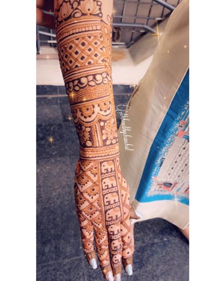 A single arm view of the elephant band engagement mehendi.