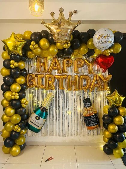 A fun and festive setup for an adult birthday, featuring champagne and whiskey bottle foil balloons.