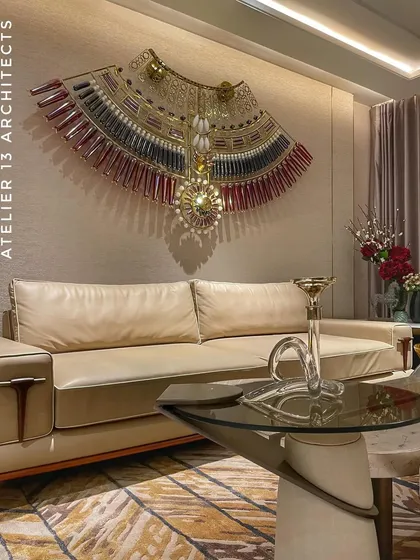A close look at a luxurious lounge area where a custom glass necklace by KLOVE STUDIO serves as the focal point. The art piece is complemented by a supple beige Italian leather sofa and Giardini fabric wallpaper, showcasing our focus on integrating statement art with refined materials.